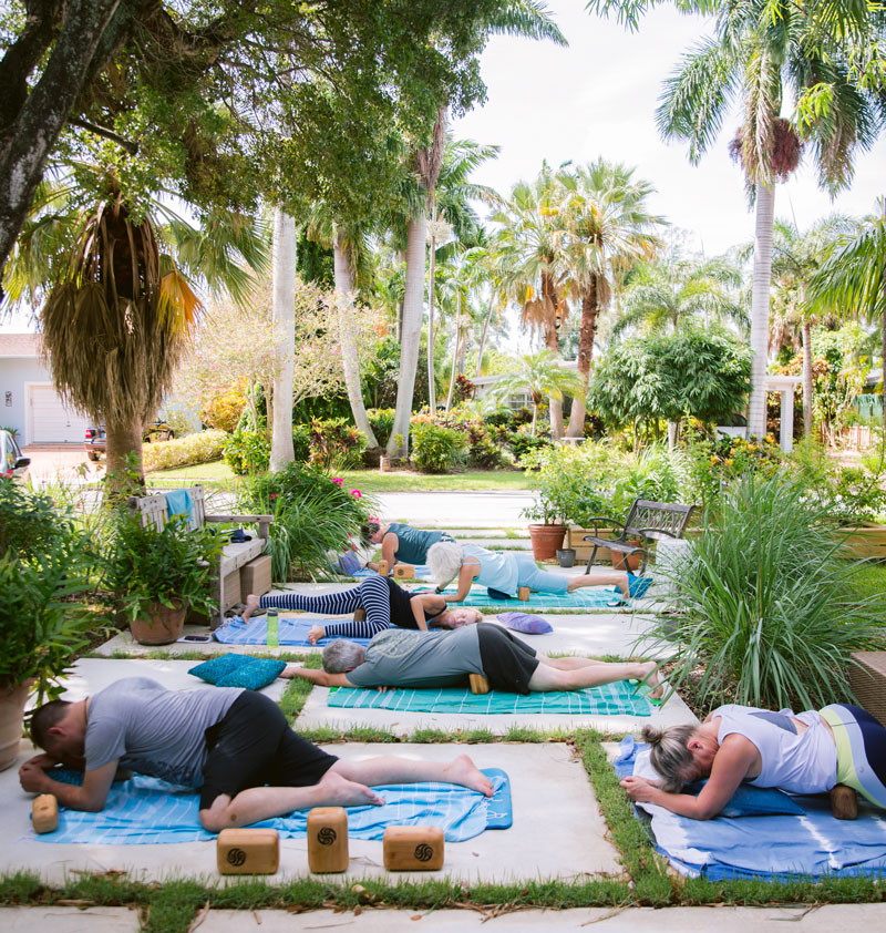 photo of a group Block Therapy class under palm trees in a residential neighborhood.