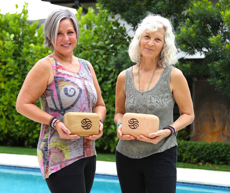 Photo of Stephanie & Michele holding Block Buddy's by a pool.